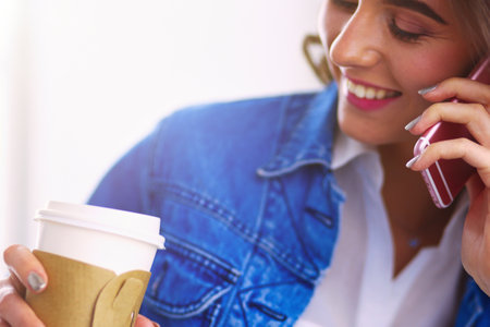 Young businesswoman talking on the phone in coffee shopの写真素材