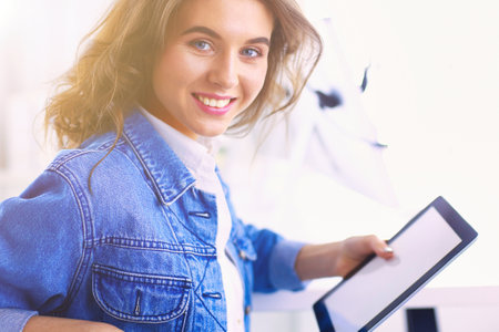 Portrait of beautiful business woman working at her desk with headset and laptopの写真素材