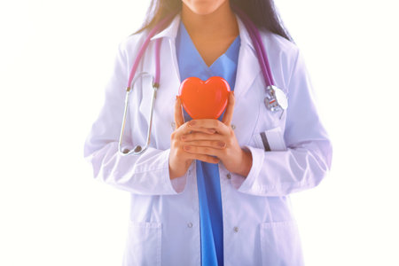 Doctor with stethoscope holding heart, isolated on white backgroundの写真素材