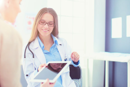 Doctor and patient discussing something while sitting at the table . Medicine and health care conceptの写真素材