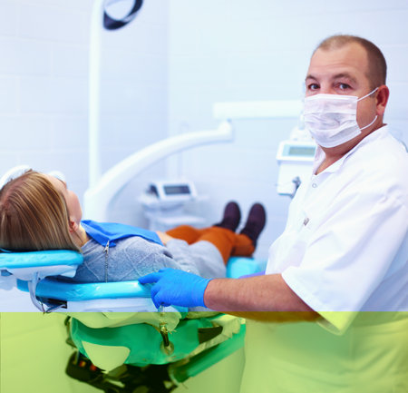 Senior male dentist in dental office talking with female patient and preparing for treatmentの写真素材