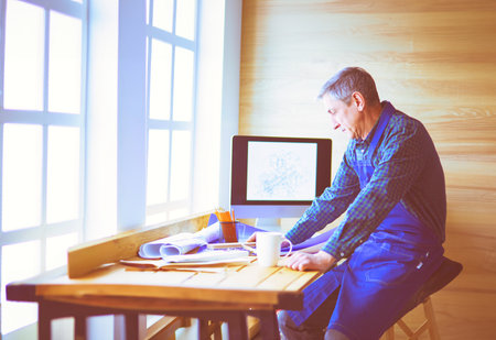 Architect working on drawing table in officeの写真素材