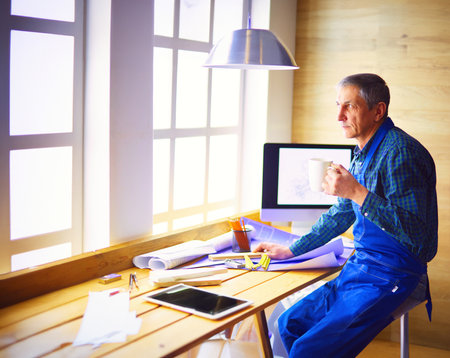Architect working on drawing table in officeの写真素材
