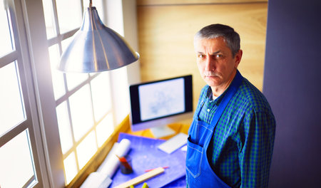 Architect working on drawing table in officeの写真素材