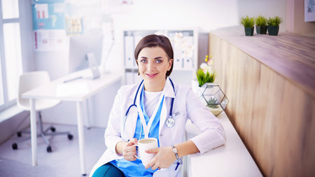 Portrait of professional female doctor holding cup of coffeeの写真素材