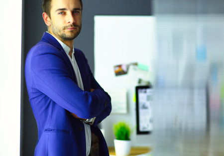Portrait of young designer in front of laptop and computer while working.の写真素材
