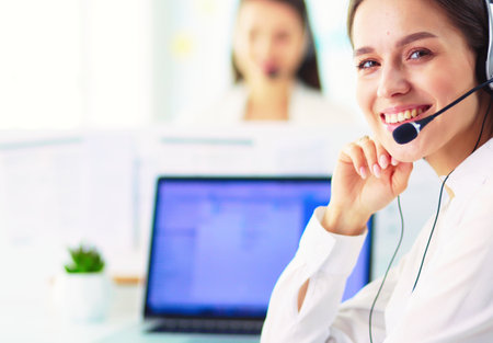 Smiling businesswoman or helpline operator with headset and computer at officeの写真素材