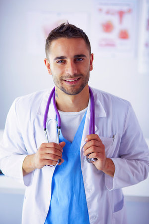 Young and confident male doctor portrait standing in medical office.の写真素材