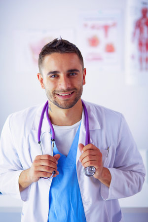 Young and confident male doctor portrait standing in medical office.の写真素材