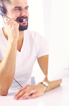 Portrait of a young man with a headset in front of a laptop computerの写真素材