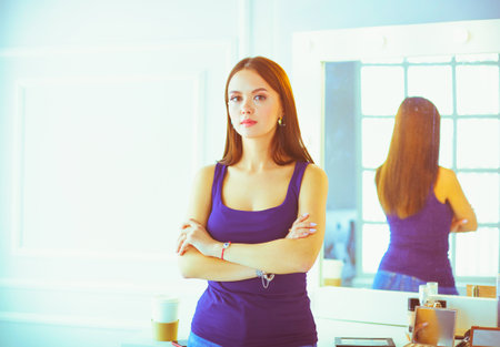 Woman standing with hands folded in her salonの写真素材