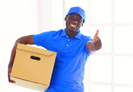 Portrait of an handsome happy deliverer with boxの写真素材