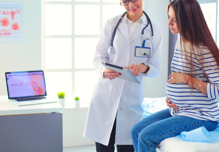 Beautiful smiling pregnant woman with the doctor at hospitalの写真素材