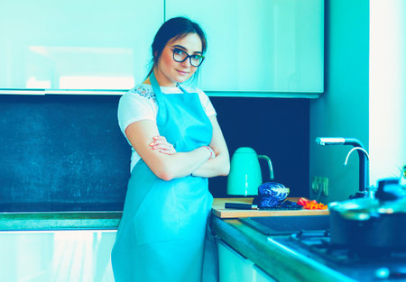 Woman cooking in new kitchen making healthy food with vegetablesの写真素材