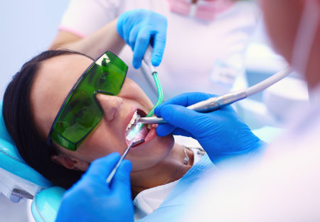 Dental team and patient at dentists surgeryの写真素材