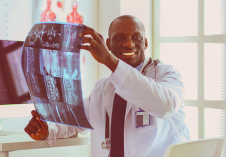 Portrait young african medical doctor holding patients x-rayの写真素材