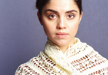 A woman wearing a beige knitted scarfの写真素材