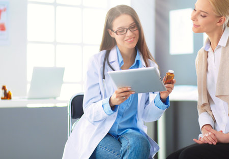 Doctor and patient discussing something while sitting at the table . Medicine and health care conceptの写真素材