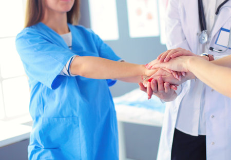 Doctors and nurses in a medical team stacking handsの写真素材