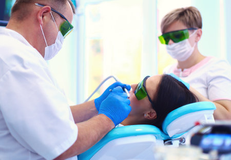 Portrait of a dentist who treats teeth of young woman patientの写真素材