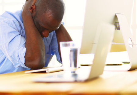 African american businessman on headset working on his laptopの写真素材