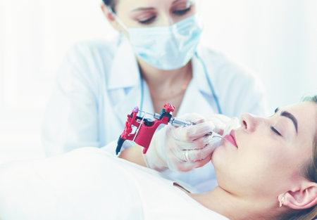 A young girl having red lips permanent makeup, micropigmentationの写真素材