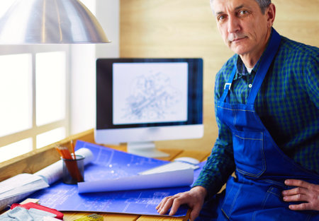 Architect working on drawing table in officeの写真素材