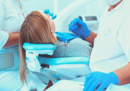 Dentist and his assistant carrying out a thorough examinationの写真素材