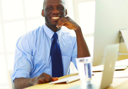 African american businessman on headset working on his laptopの写真素材