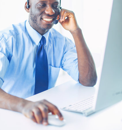 African american businessman on headset working on his laptopの写真素材