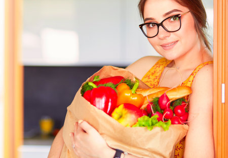 Young woman holding grocery shopping bag with vegetablesの写真素材