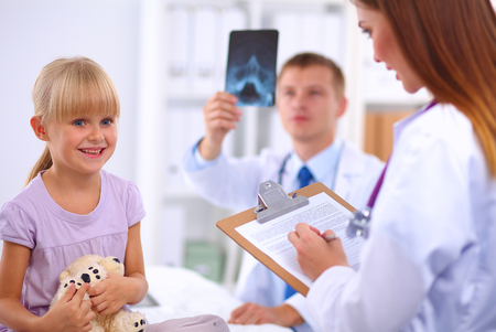 Female doctor examining child with stethoscope at surgery,isolatedの写真素材