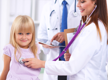 Female doctor examining child with stethoscopeの写真素材