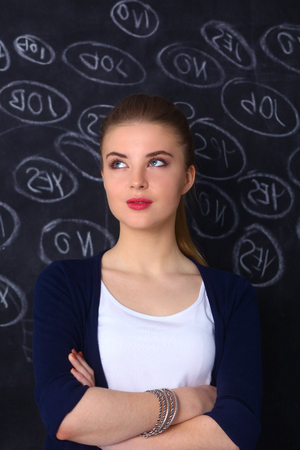 Thinking young woman with yes or no choice on gray background.の写真素材
