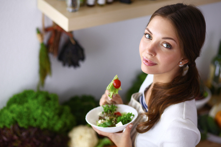 Young woman eating salad and holding a mixed salad .の写真素材