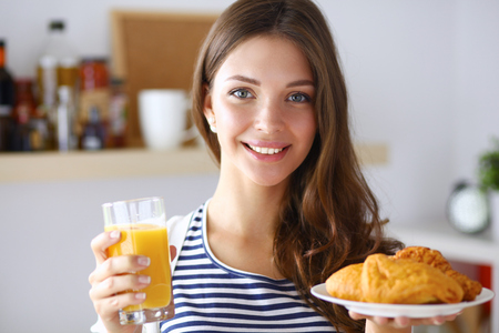 Young woman with glass of juice and cakes .の写真素材