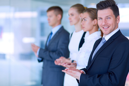 Smiling business people applauding a good presentation in the office .の写真素材