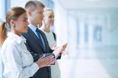 Smiling business people applauding a good presentation in the office .の写真素材