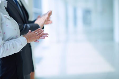 Smiling business people applauding a good presentation in the office .の写真素材