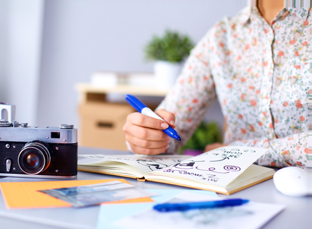 Portrait of  young woman sitting at  desk .の写真素材
