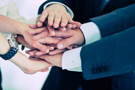 Business people with their hands together in a circle .
