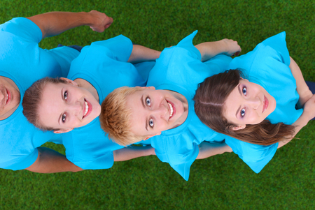 Group of young  people standing on green grass .の写真素材