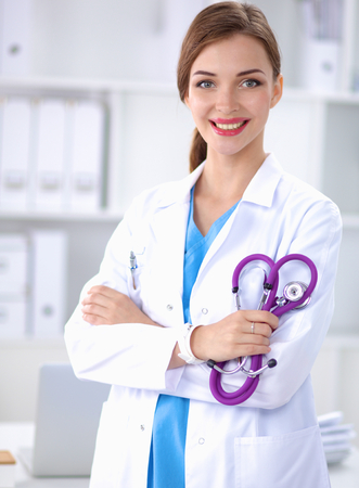 Portrait of young woman doctor with white coat standing in hospital .の写真素材