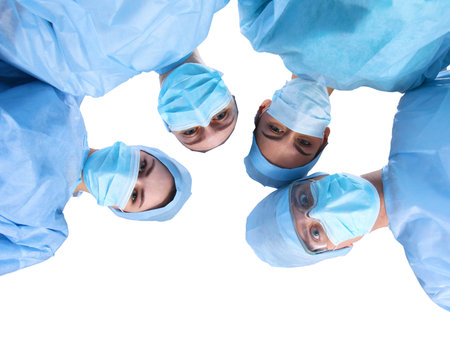 Surgeons team, man and woman wearing protective uniforms,caps and masks.