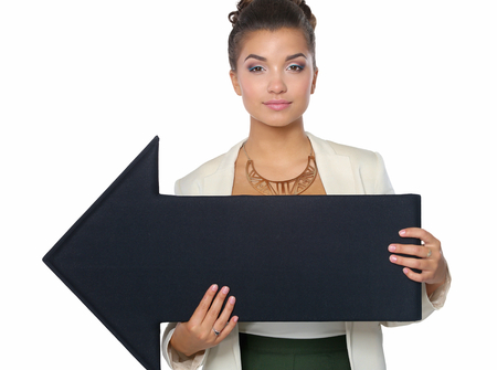 Beautiful young business woman holding a black arrows, over a white background.の写真素材