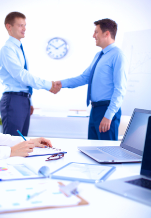Business people shaking hands, finishing up a meeting, in office.の写真素材