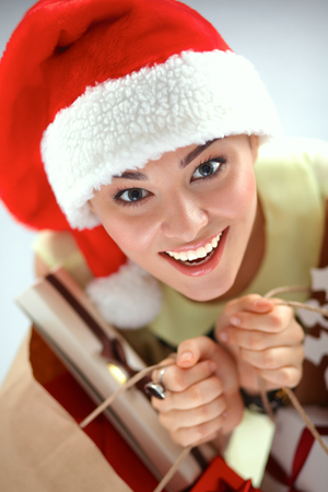 Happy girl on santa hat with gift box on red background.の写真素材