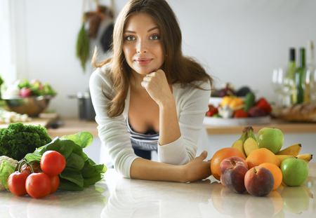 Young woman sitting near desk in the kitchenの写真素材