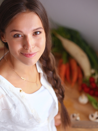 Young woman standing near desk in the kitchenの写真素材