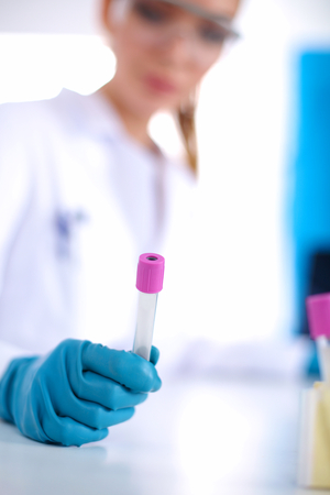 Woman researcher is surrounded by medical vials and flasks, isolated on whiteの写真素材